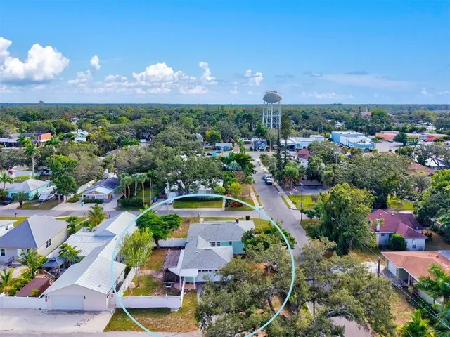 a view of a house with a yard and large tree