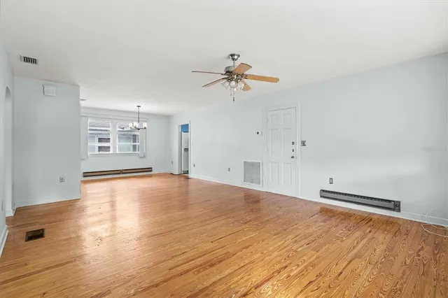 a view of empty room with cabinet and wooden floor