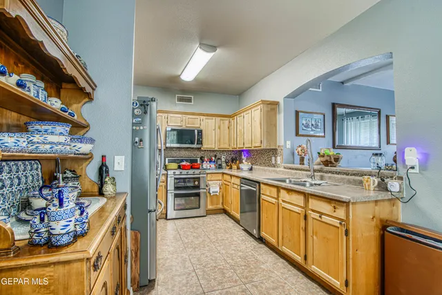 a kitchen with granite countertop lots of clutter and stainless steel appliances