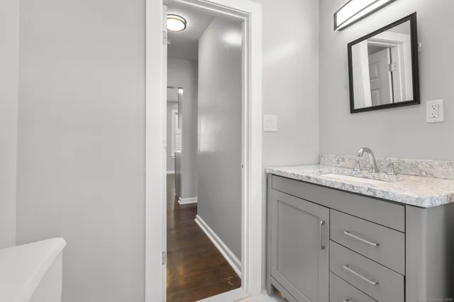 a bathroom with a granite countertop sink and a mirror