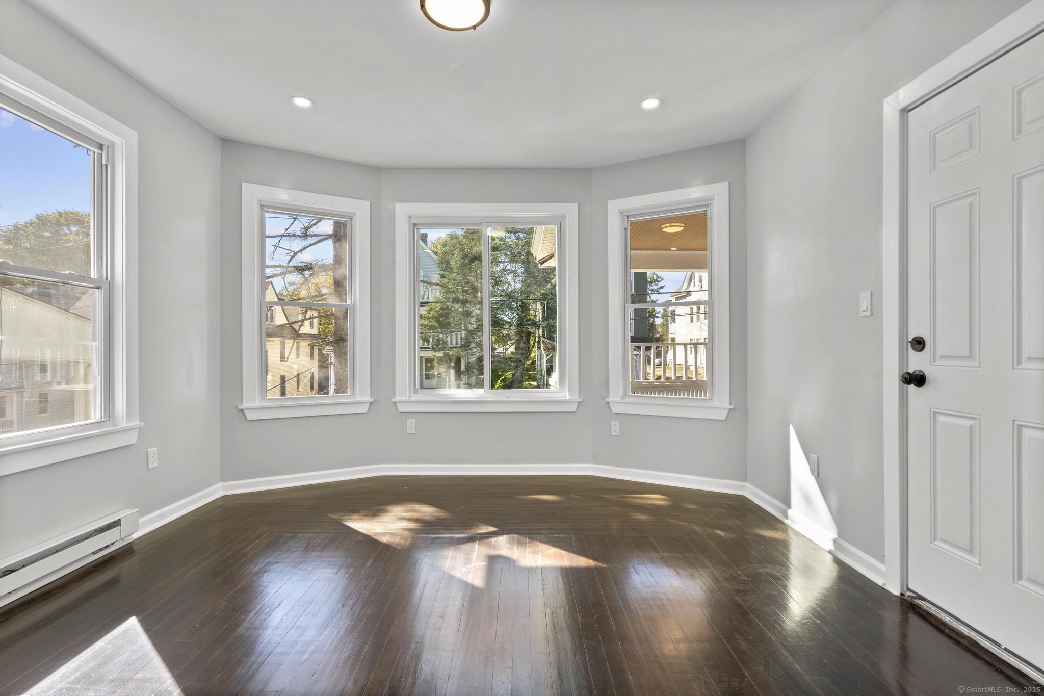 230 Cooke Street, Unit 2 Waterbury, CT 06710 - Photo 2 of 16 a view of an empty room with wooden floor and a window