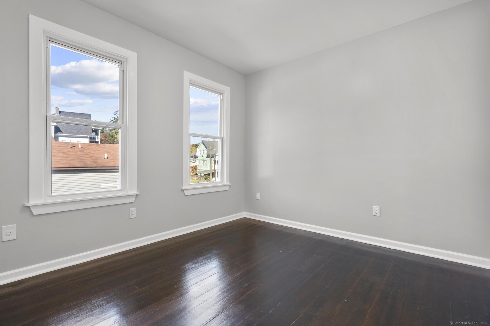230 Cooke Street, Unit 2 Waterbury, CT 06710 - Photo 6 of 16 a view of an empty room with wooden floor and a window