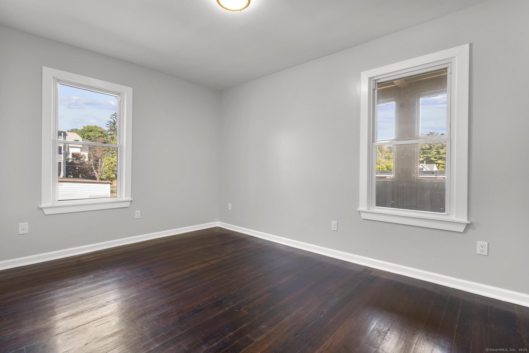 230 Cooke Street, Unit 2 Waterbury, CT 06710 - Photo 9 of 16 a view of an empty room with wooden floor and a window
