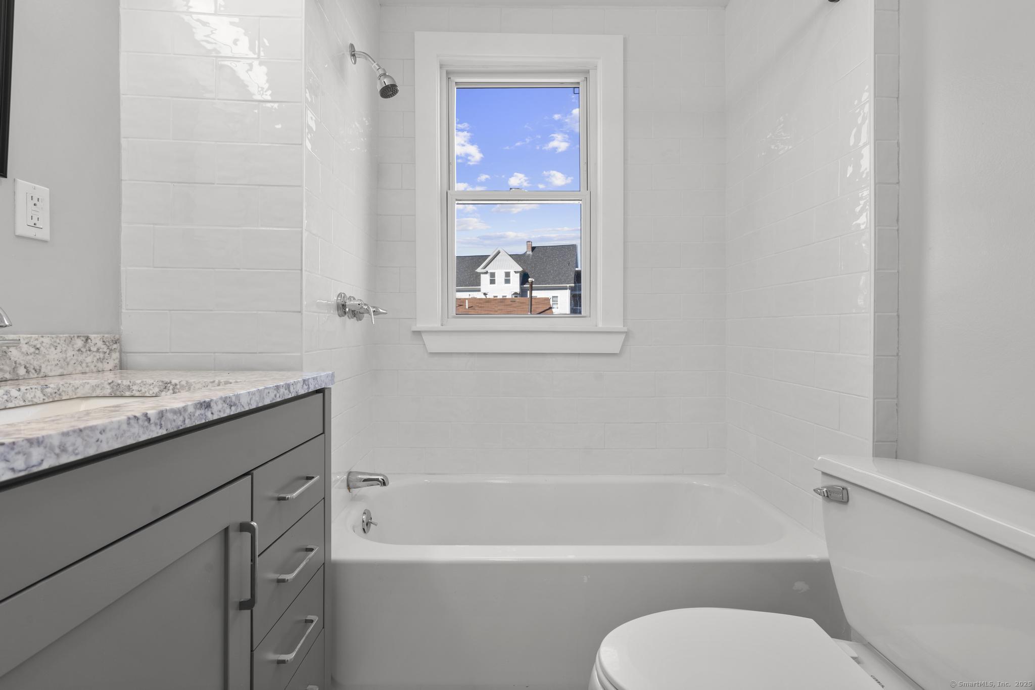 230 Cooke Street, Unit 2 Waterbury, CT 06710 - Photo 10 of 16 a bathroom with a granite countertop toilet sink and bathtub