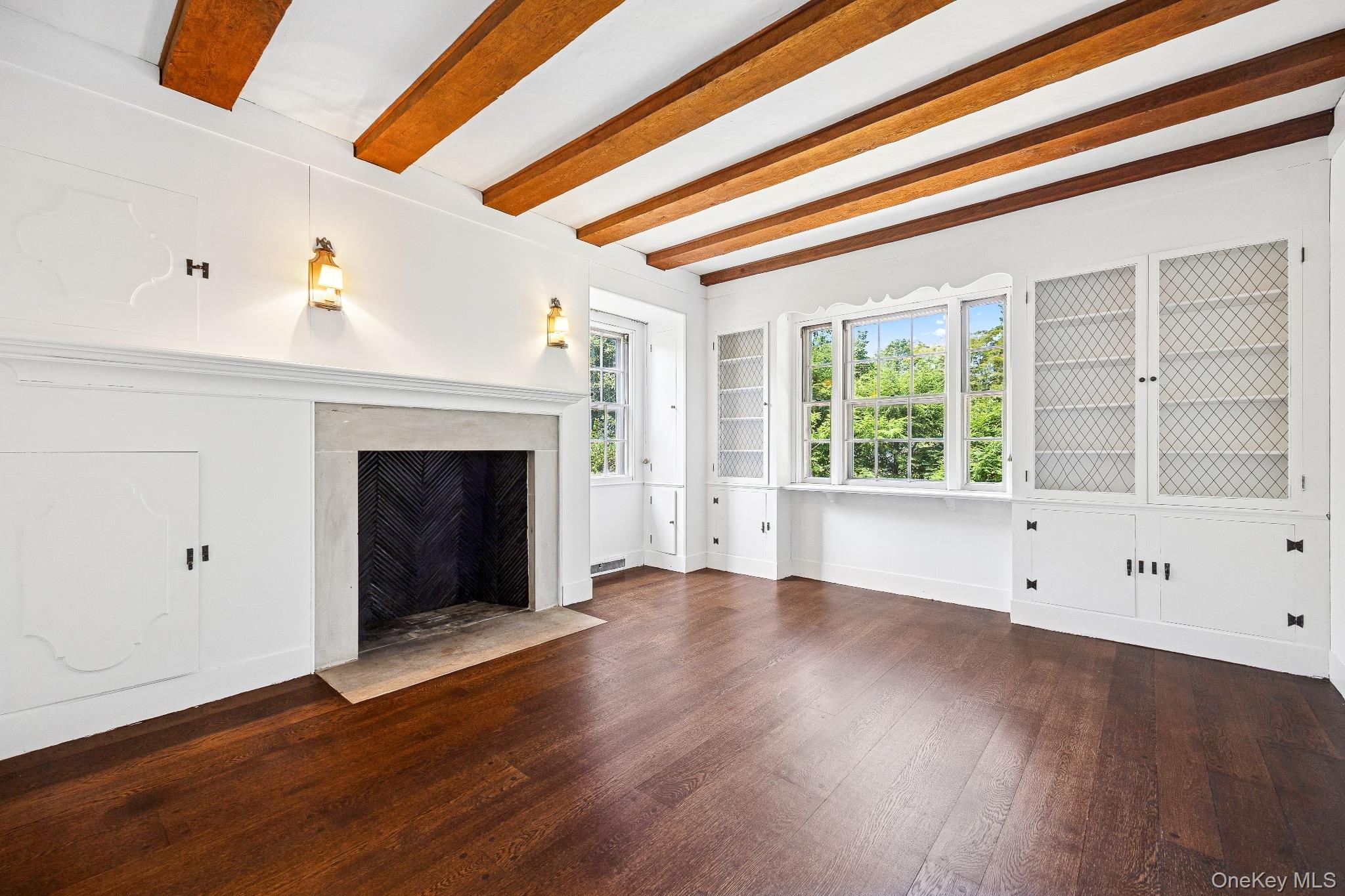 6 Fox Meadow Road Scarsdale, NY 10583 - Photo 3 of 20 Unfurnished living room with beamed ceiling, a high end fireplace, and wood finished floors