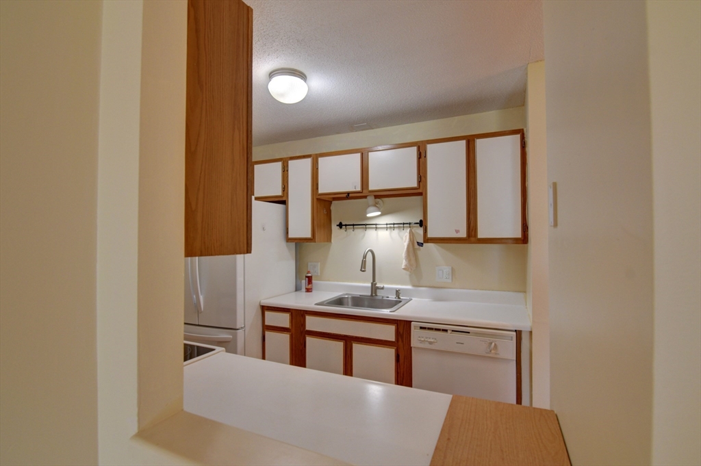15 Bower Road, Unit A11 Quincy, MA 02169 - Photo 14 of 29 a kitchen with kitchen island a stove a sink and a refrigerator