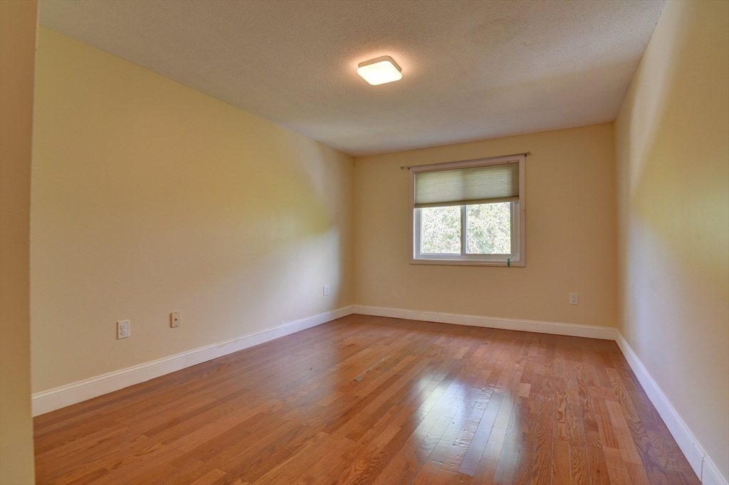 15 Bower Road, Unit A11 Quincy, MA 02169 - Photo 16 of 29 an empty room with wooden floor and windows