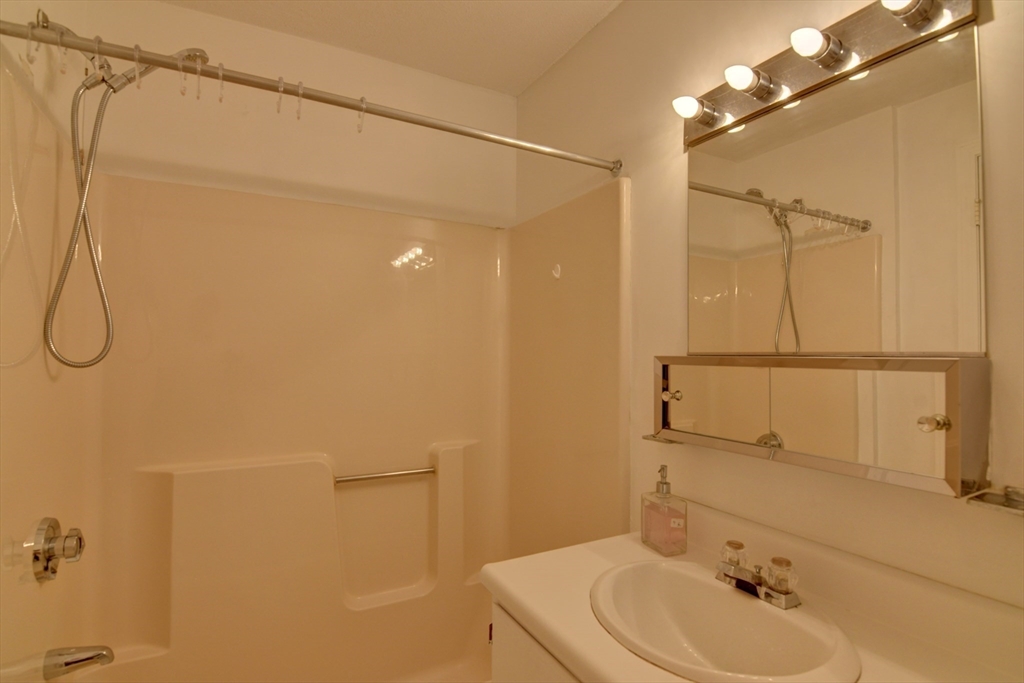 15 Bower Road, Unit A11 Quincy, MA 02169 - Photo 20 of 29 a bathroom with a sink a shower and a mirror