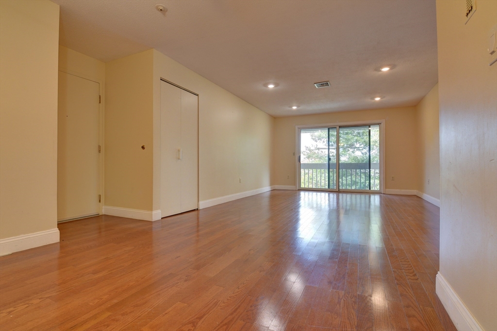 15 Bower Road, Unit A11 Quincy, MA 02169 - Photo 2 of 29 a view of an empty room with wooden floor and a window