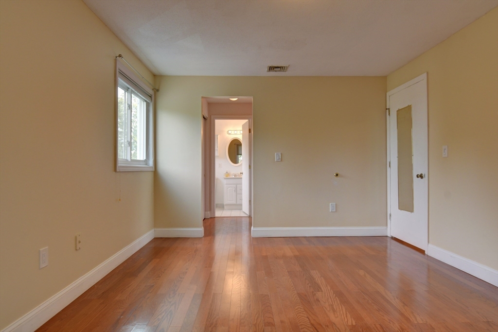 15 Bower Road, Unit A11 Quincy, MA 02169 - Photo 26 of 29 an empty room with wooden floor and windows