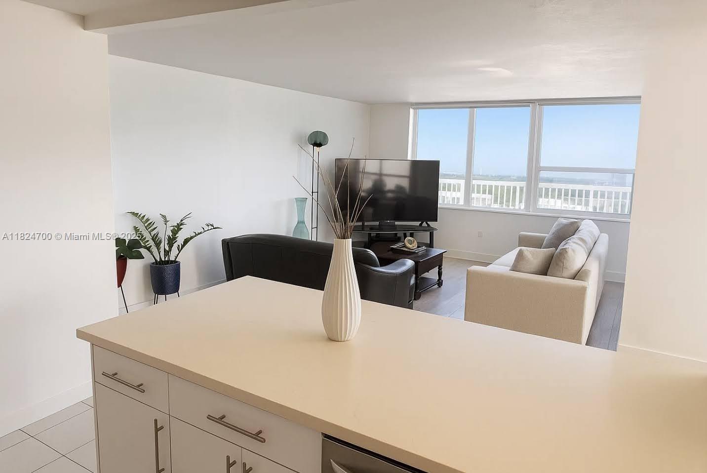 2750 Northeast 183rd Street, Unit 2103 Aventura, FL 33160 - Photo 6 of 30 a living room with furniture a flat screen tv and a window