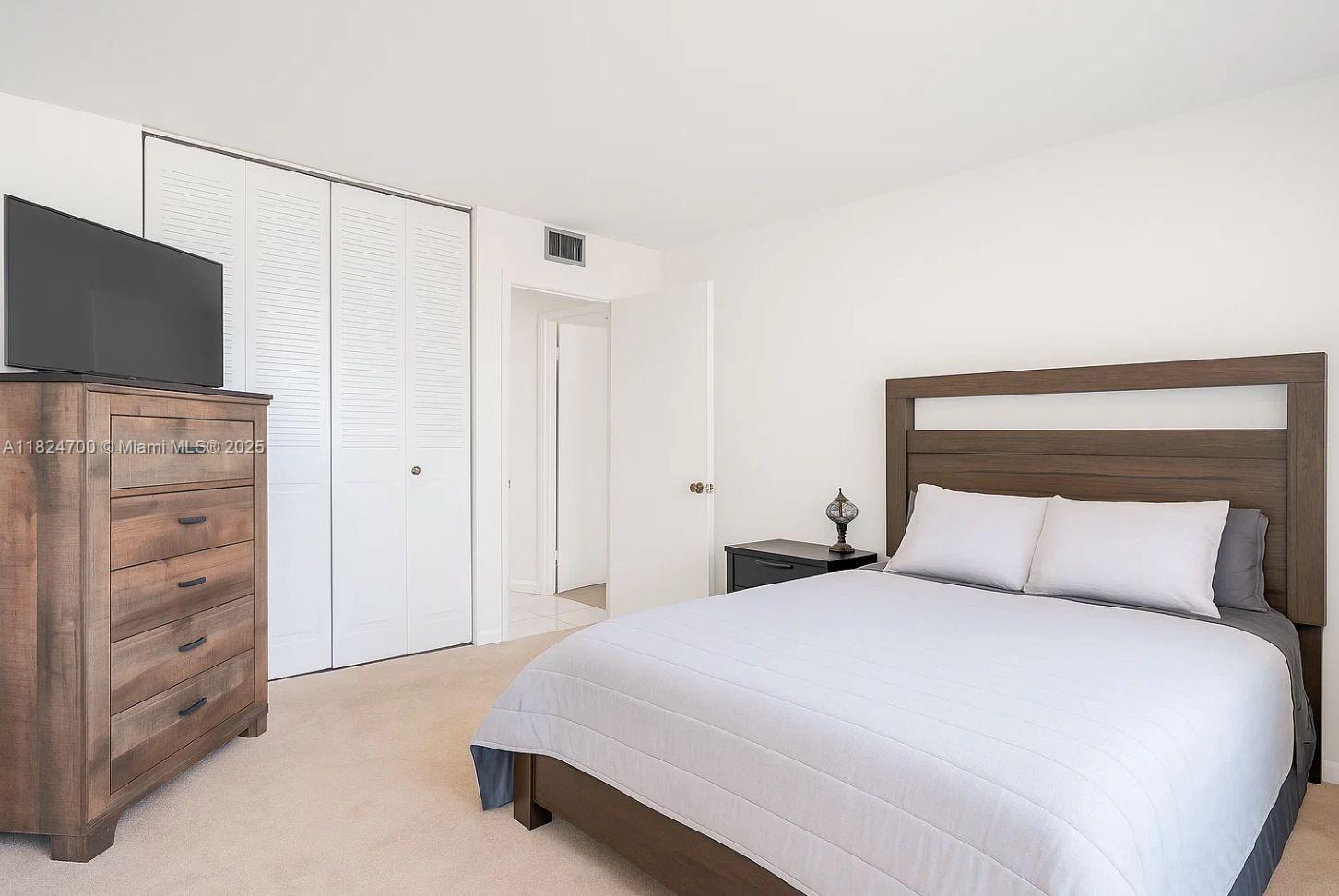 2750 Northeast 183rd Street, Unit 2103 Aventura, FL 33160 - Photo 8 of 30 a bedroom with a bed and a flat screen tv