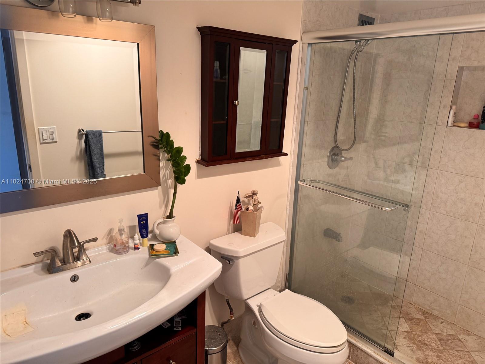 2750 Northeast 183rd Street, Unit 2103 Aventura, FL 33160 - Photo 10 of 30 a bathroom with a sink a mirror a toilet and shower