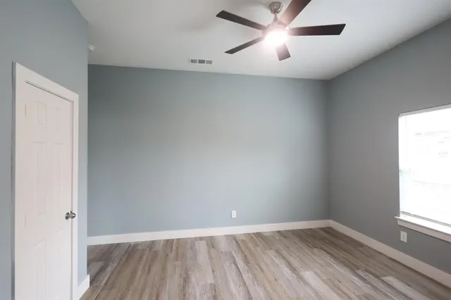 an empty room with a window and wooden floor