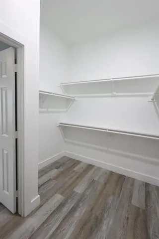 a view of a closet with wooden floor