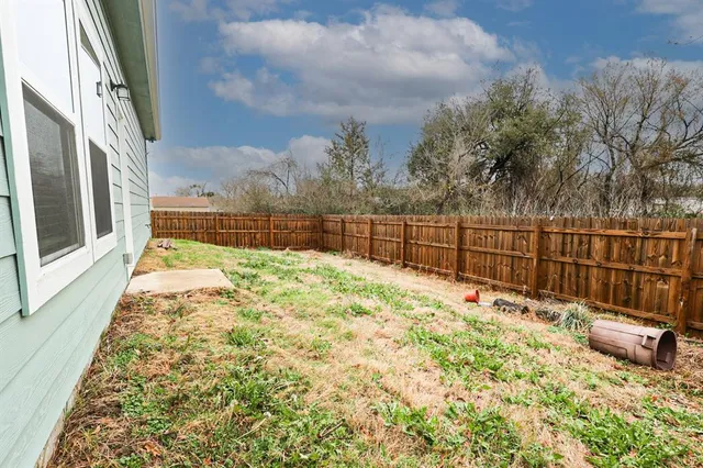 a view of backyard with wooden fence