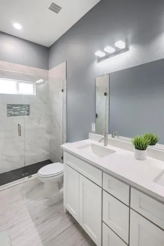 a bathroom with a sink a toilet and shower