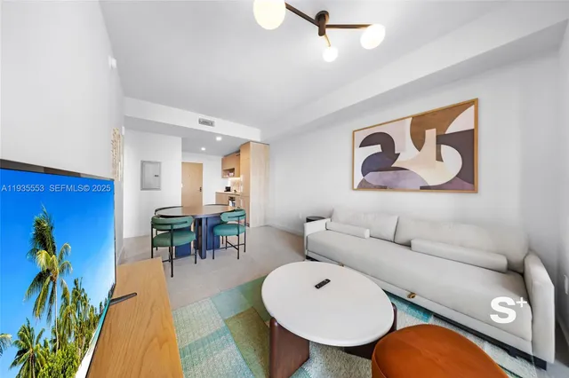 a living room with furniture and a dining table