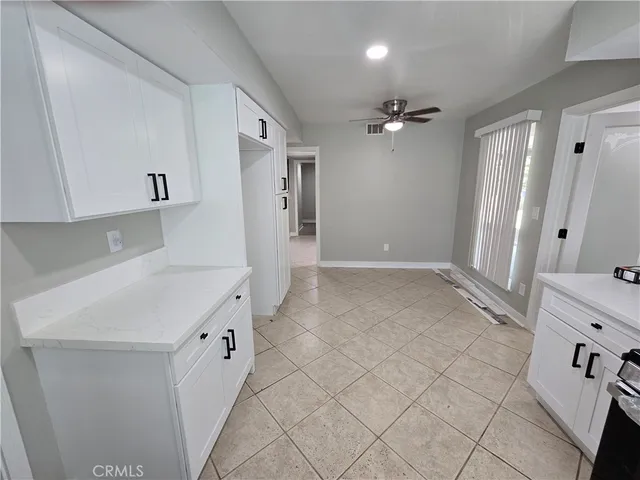 a kitchen with granite countertop white cabinets and refrigerator