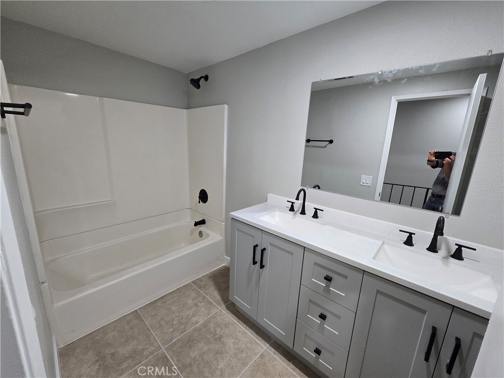 775 Libby Drive Riverside, CA 92507 - Photo 17 of 28 a bathroom with a tub sink double vanity and mirror