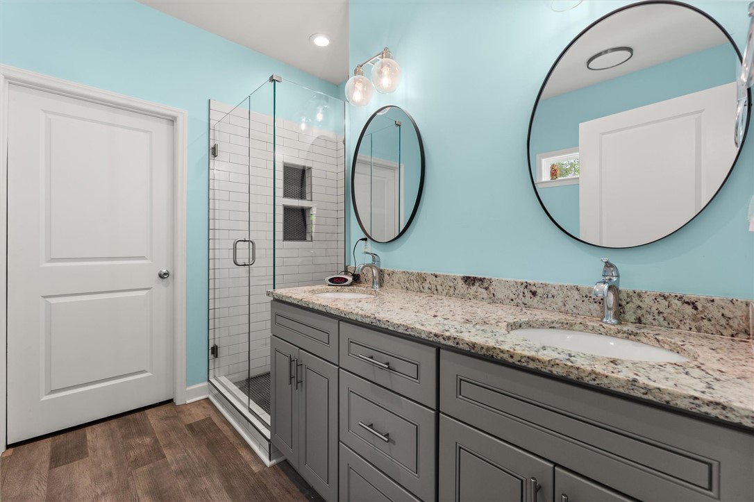 67 Sawblade Ridge Marietta, SC 29661 - Photo 16 of 37 This bathroom features a double vanity with granite counters and a spacious glass-enclosed shower.