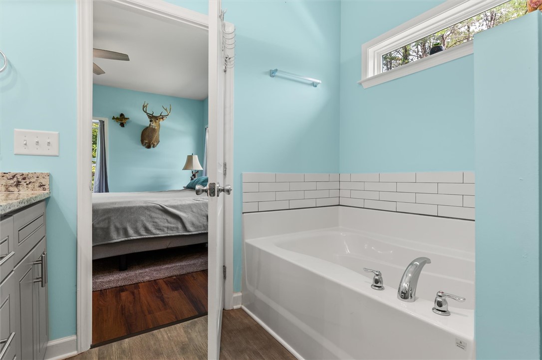 67 Sawblade Ridge Marietta, SC 29661 - Photo 17 of 37 This primary suite offers direct bathroom access, featuring a tiled soaking tub and a spacious walk-in shower.