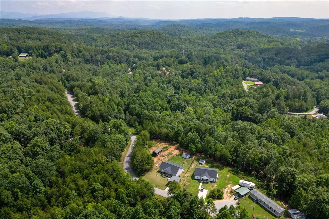 67 Sawblade Ridge Marietta, SC 29661 - Photo 6 of 37 This aerial view showcases a residential property nestled amidst expansive, lush forests and rolling hills.