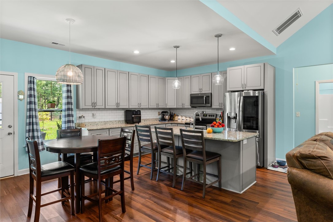 67 Sawblade Ridge Marietta, SC 29661 - Photo 7 of 37 This bright kitchen features wood flooring and a kitchen island, perfect for gathering.