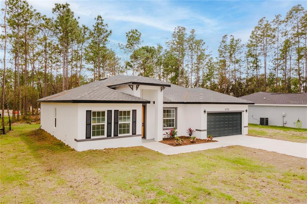 6732 Southwest 132nd Street Ocala, FL 34473 - Photo 3 of 36 a view of a white house with a swimming pool and sitting area