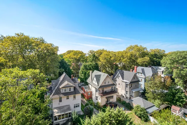 an aerial view of residential houses with outdoor space and trees