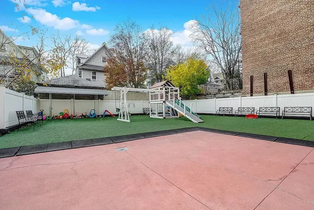 a view of a white house with a big yard and large trees