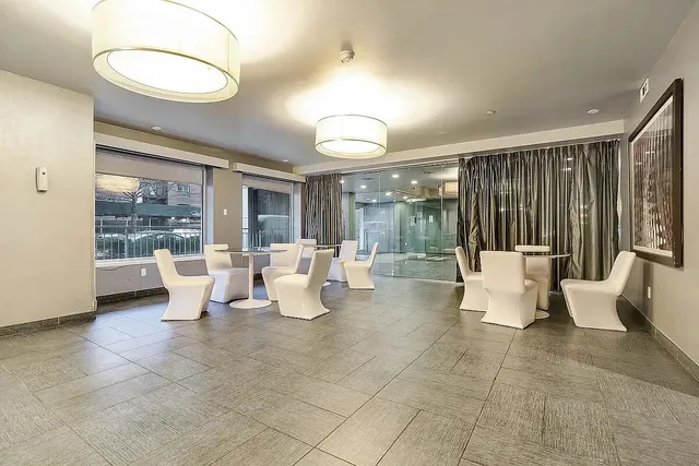 a living room with couches and a dining table with garden view