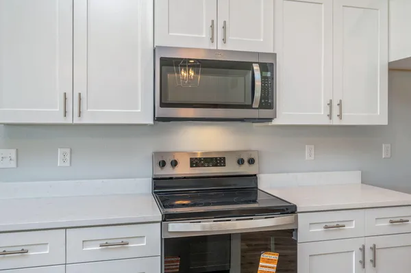 a kitchen with appliances a stove and cabinets