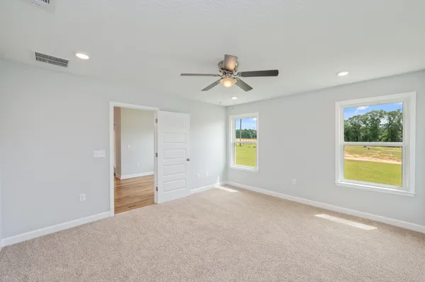 an empty room with a window and a ceiling fan