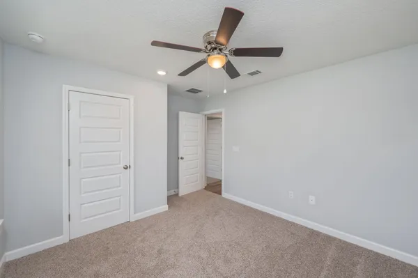 an empty room with a window and a fan