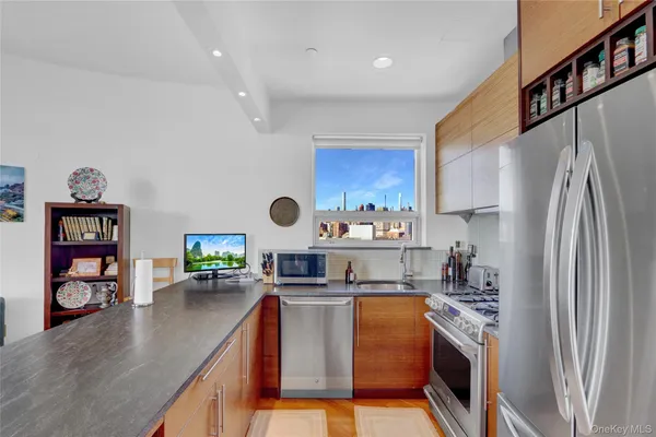 a kitchen with stainless steel appliances granite countertop a refrigerator a stove and a wooden floors