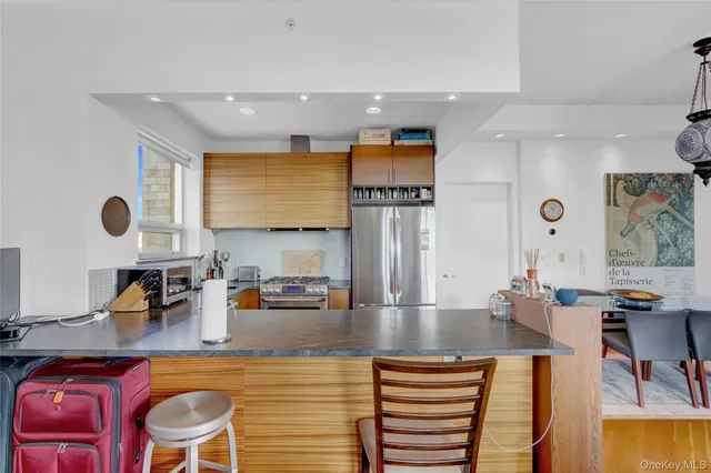 a kitchen with stainless steel appliances granite countertop a sink and a refrigerator
