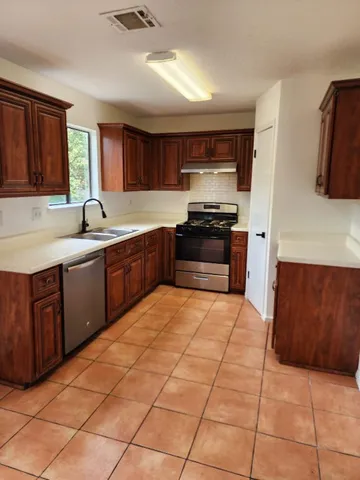 a kitchen with stainless steel appliances granite countertop a sink and cabinets