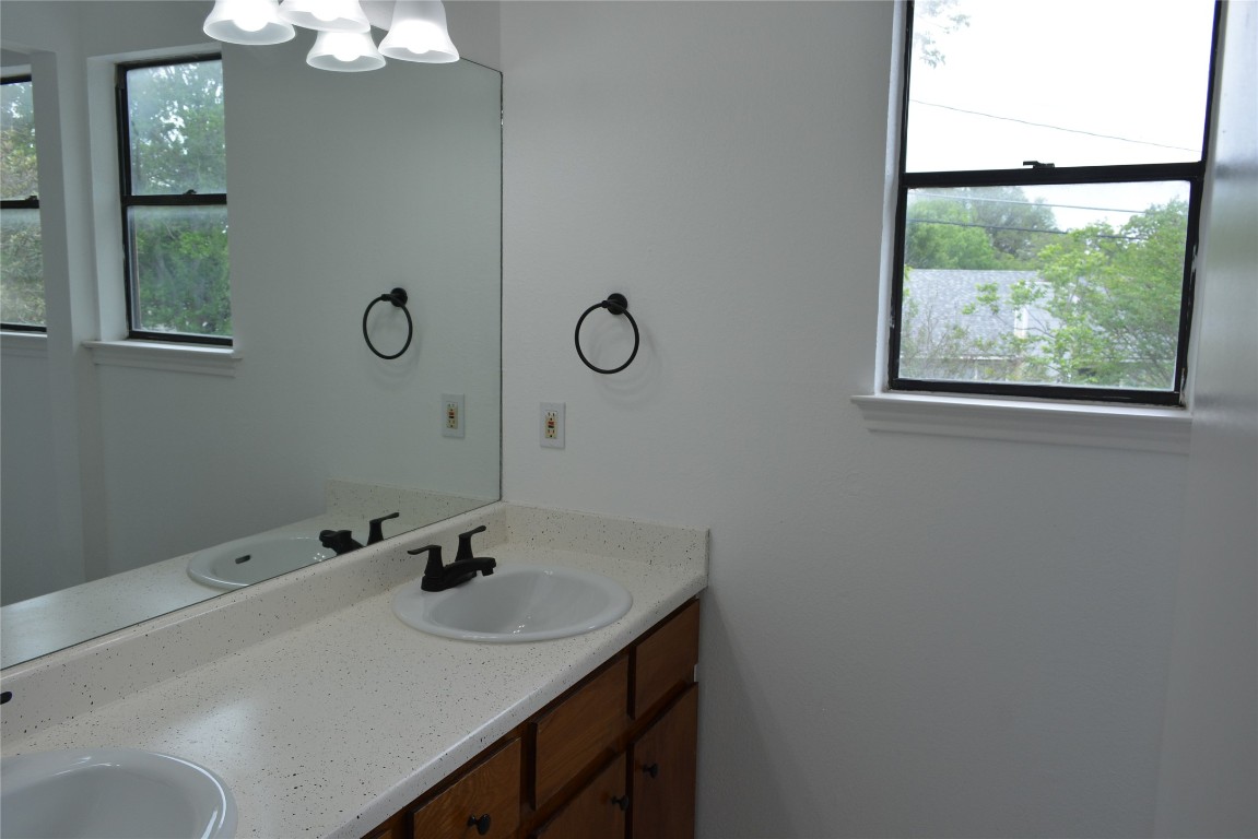 1207 Crupp Court Austin, TX 78753 - Photo 8 of 11 a bathroom with a sink and a mirror