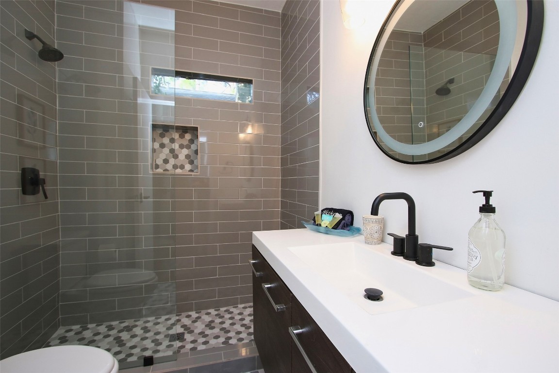 1818 Haver Street Houston, TX 77006 - Photo 20 of 28 a bathroom with a sink a toilet and a mirror