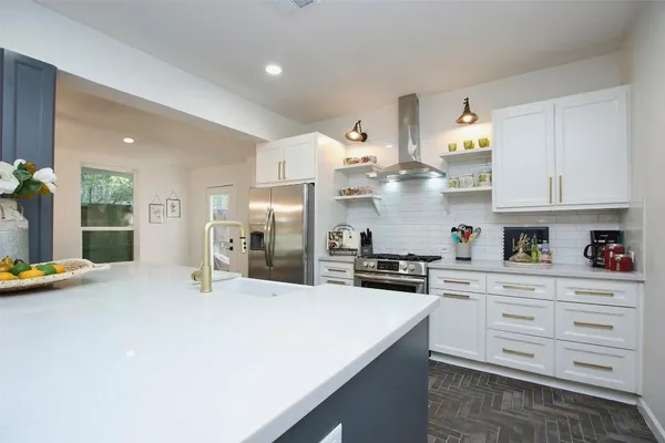 a kitchen with stainless steel appliances a sink a stove and refrigerator