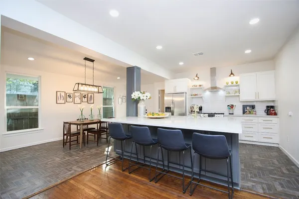 a dining hall with stainless steel appliances granite countertop a dining table chairs and window