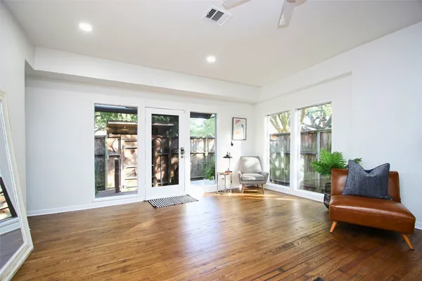 a living room with furniture and wooden floors