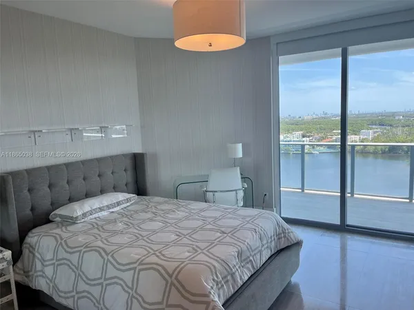 a bedroom with a bed and a large window