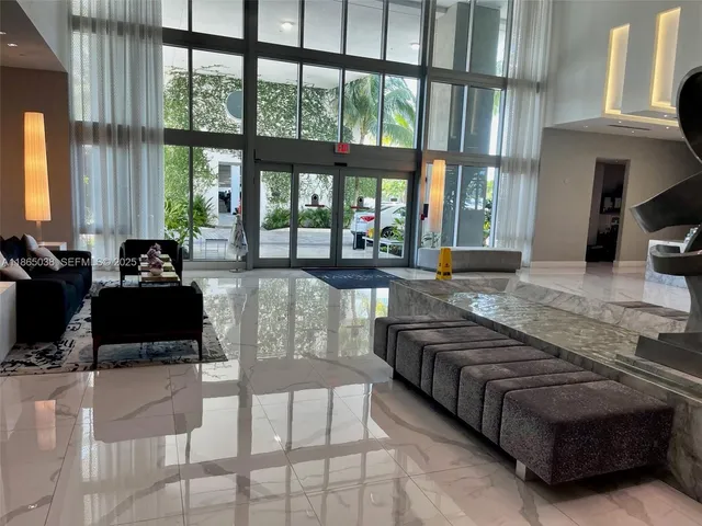 a living room with furniture and large windows