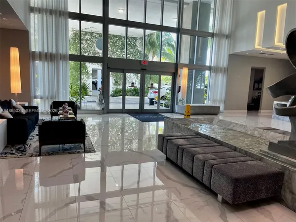 a living room with furniture and large windows
