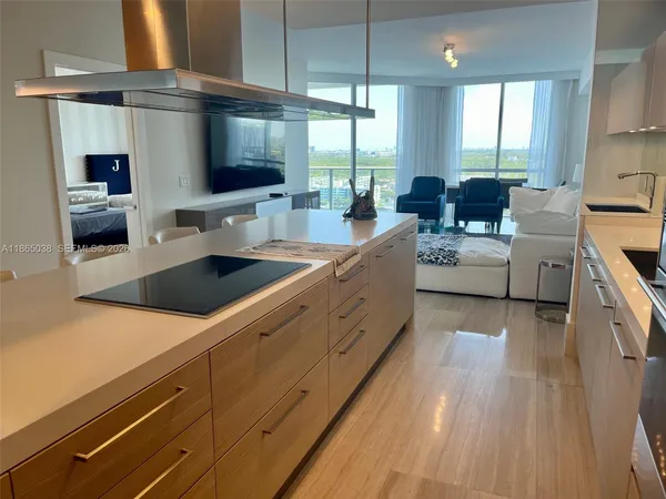 a large kitchen with stainless steel appliances granite countertop a lot of counter space and a sink