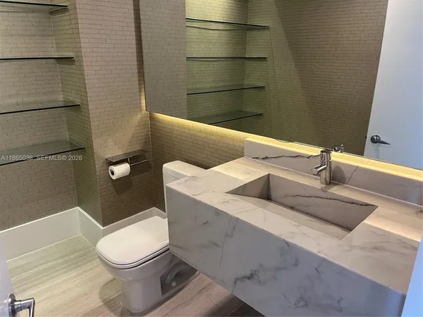 a white toilet sitting next to a bathroom sink