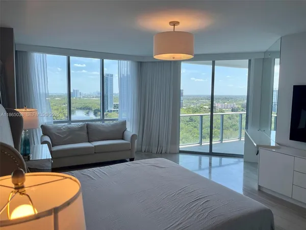 a bedroom with a bed a large window and flat screen tv