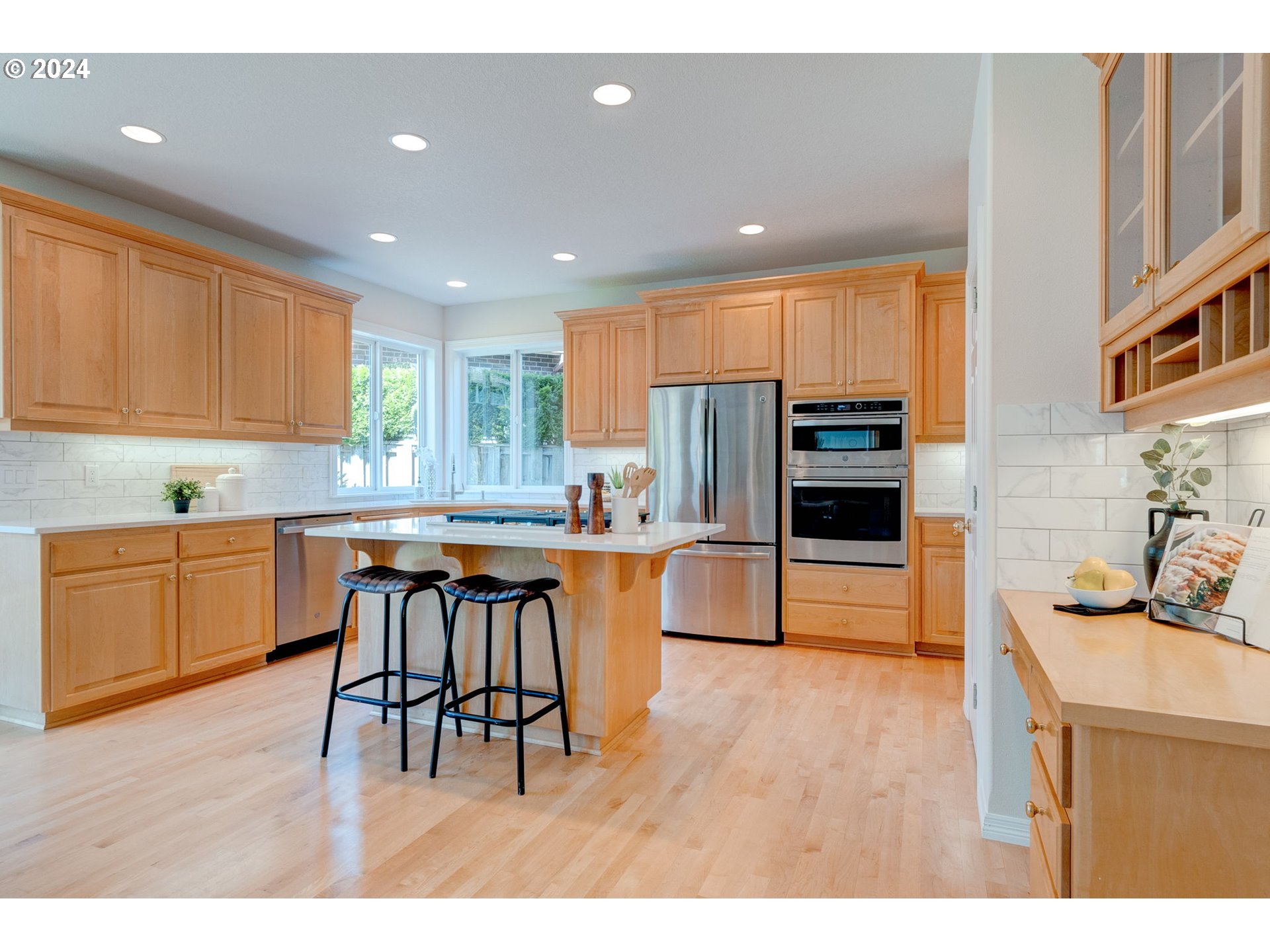 16610 Northwest Mission Oaks Drive Beaverton, OR 97006 - Photo 14 of 37 a kitchen with stainless steel appliances granite countertop a table chairs sink refrigerator and cabinets